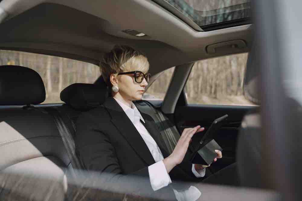 Women Sitting in Taxi and carrying Notpad in Hand